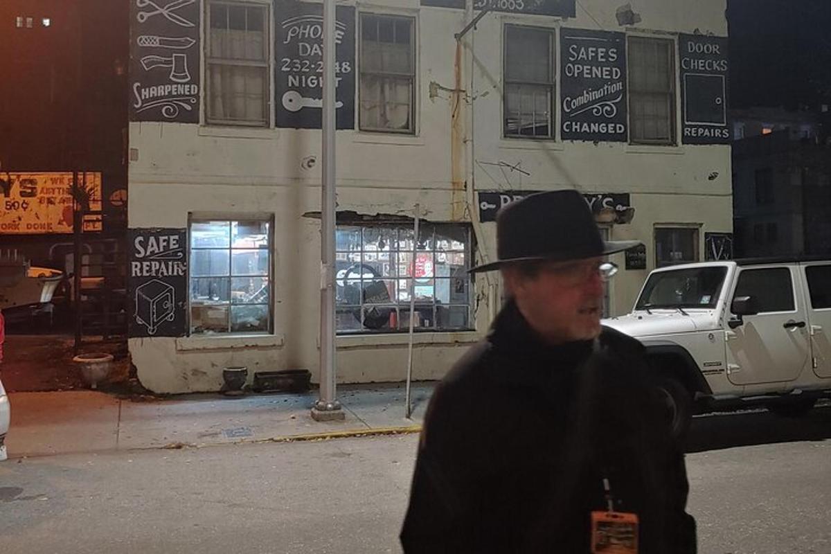 a man wearing a hat walking down a street