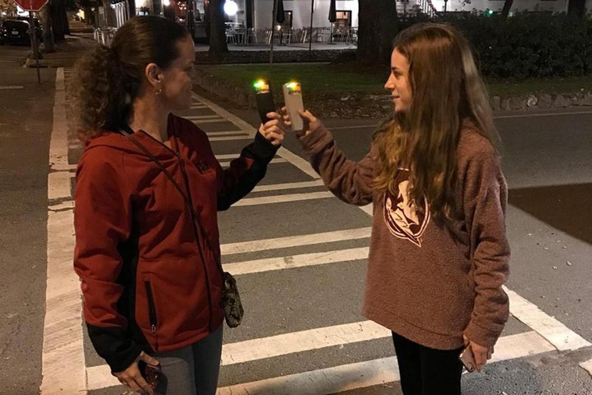two girls are holding lit candles on a street
