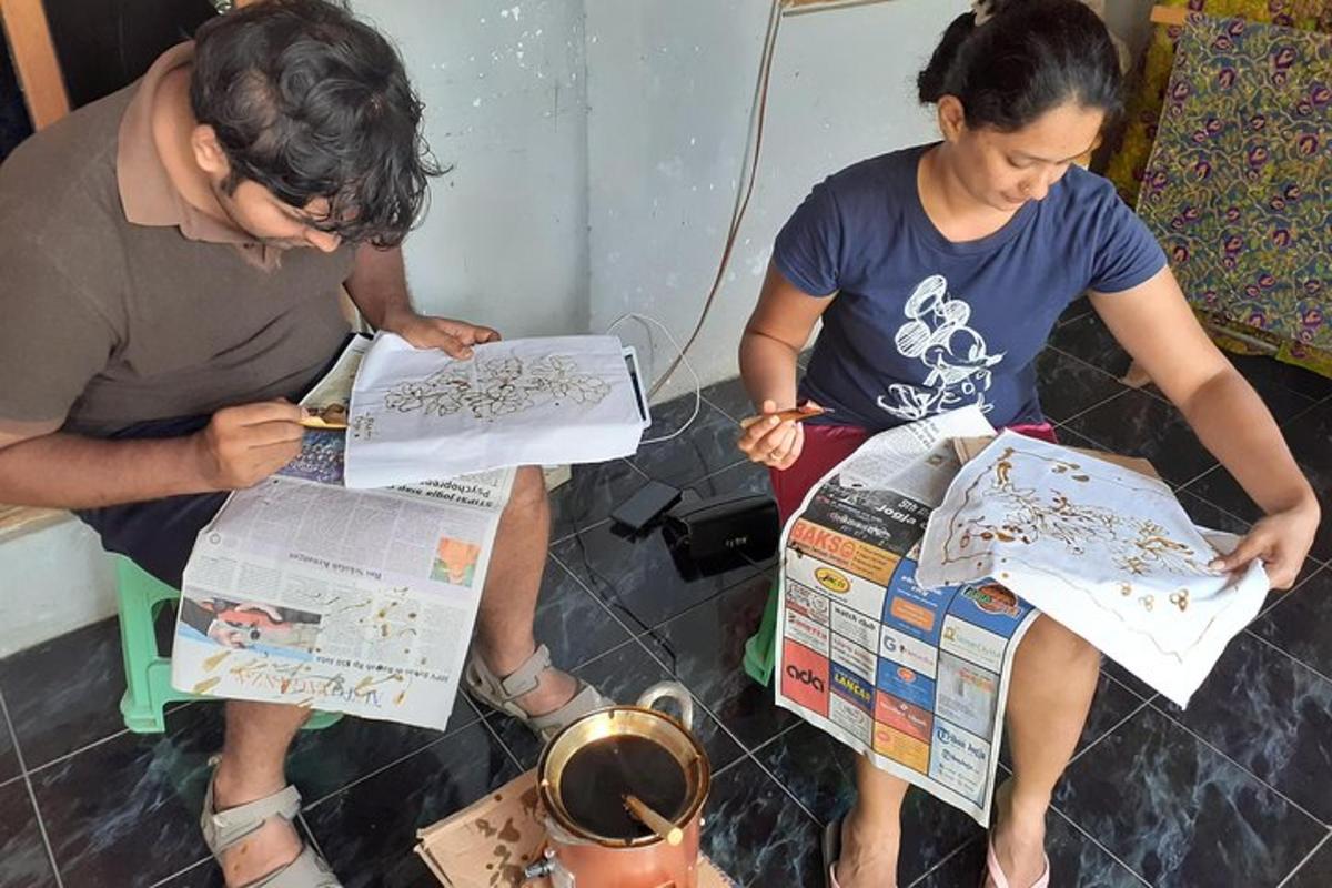 seorang lelaki dan seorang wanita duduk di atas kerusi membaca kertas