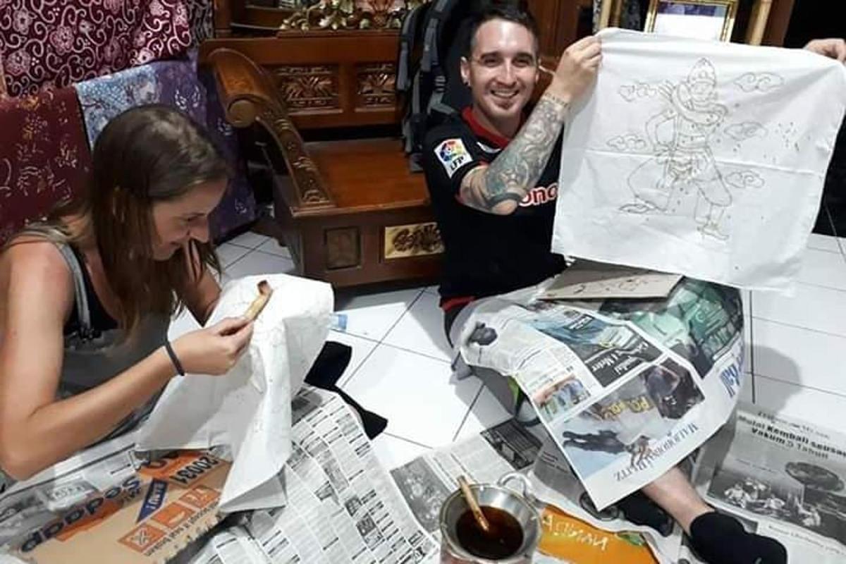 seorang lelaki dan seorang wanita duduk di meja dengan beg kertas