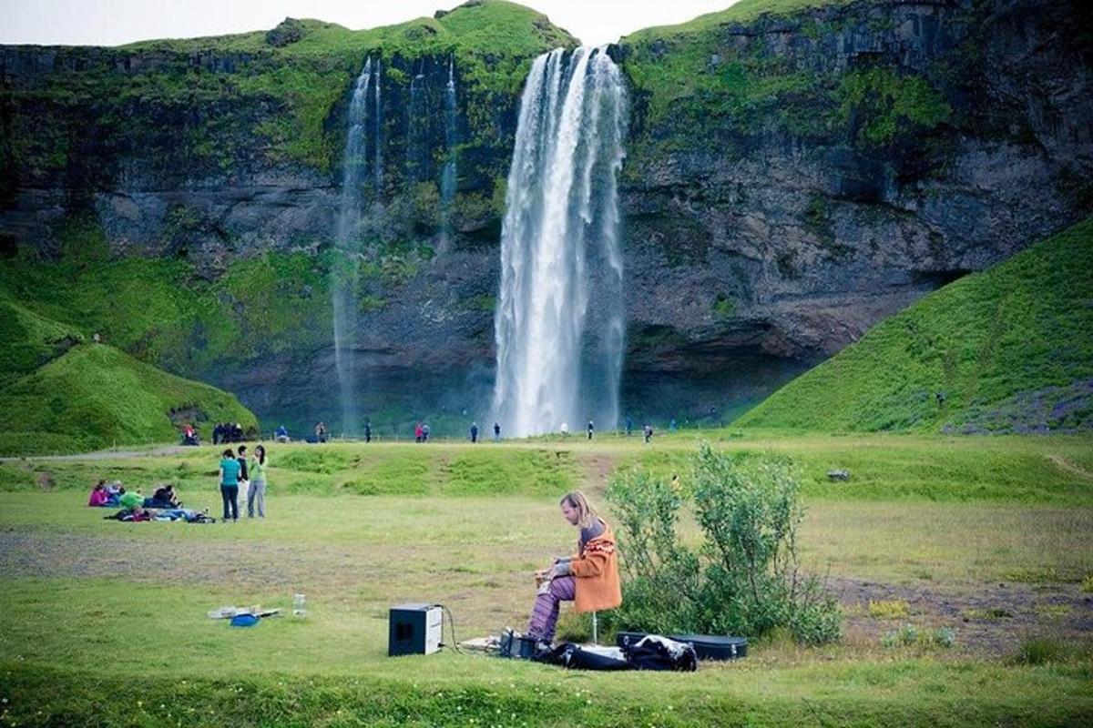 kona stendur fyrir framan foss