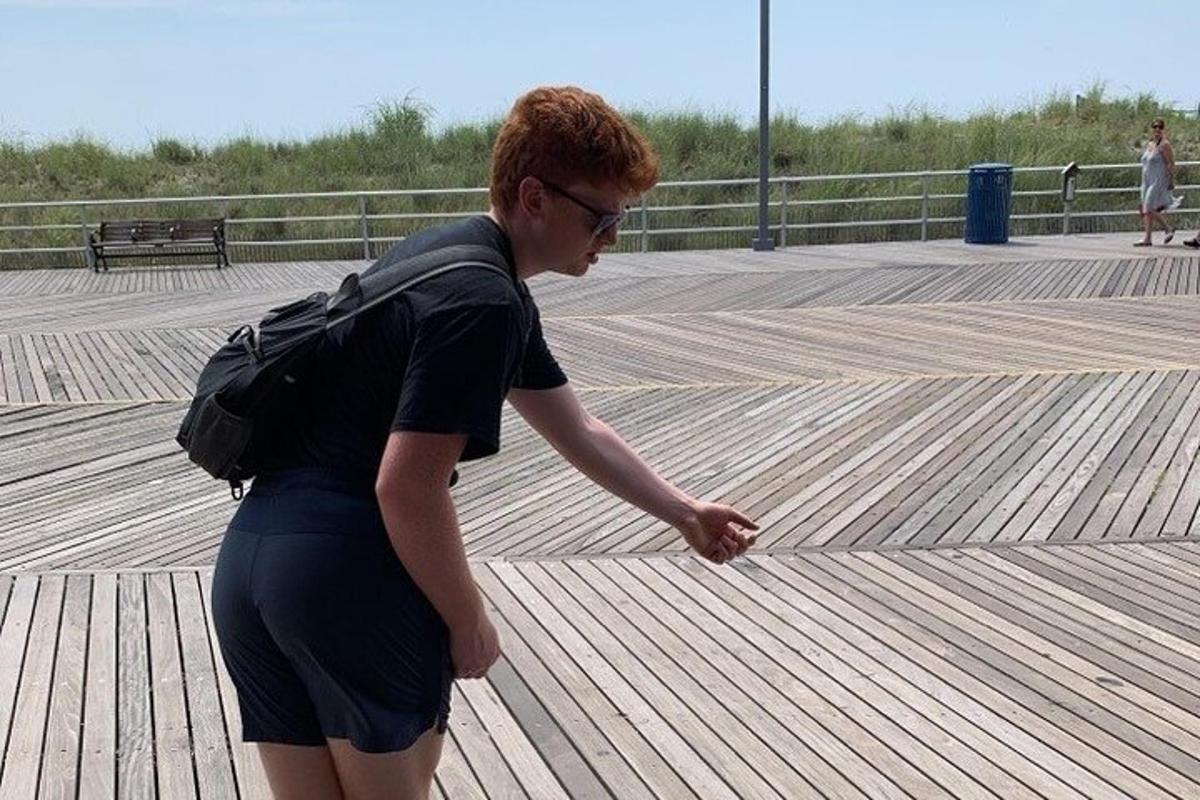 a woman with a backpack walking on a boardwalk