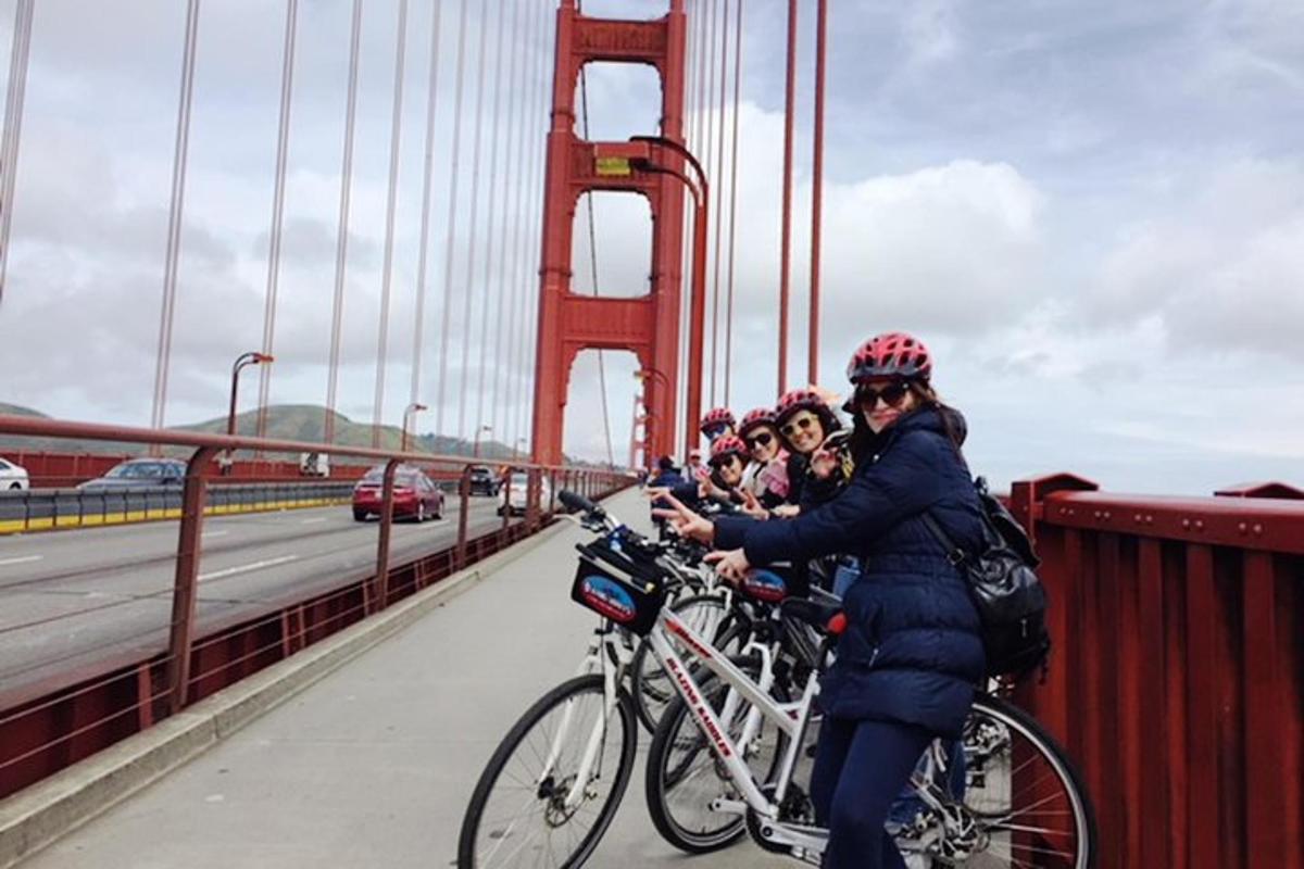 skupina ljudi, ki se vozijo s kolesi na mostu Golden Gate