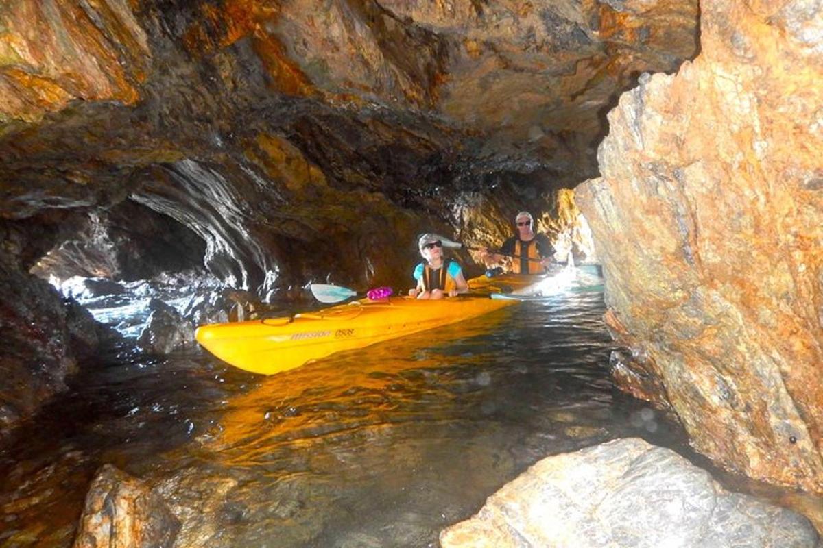 two people in a yellow kayak in a cave
