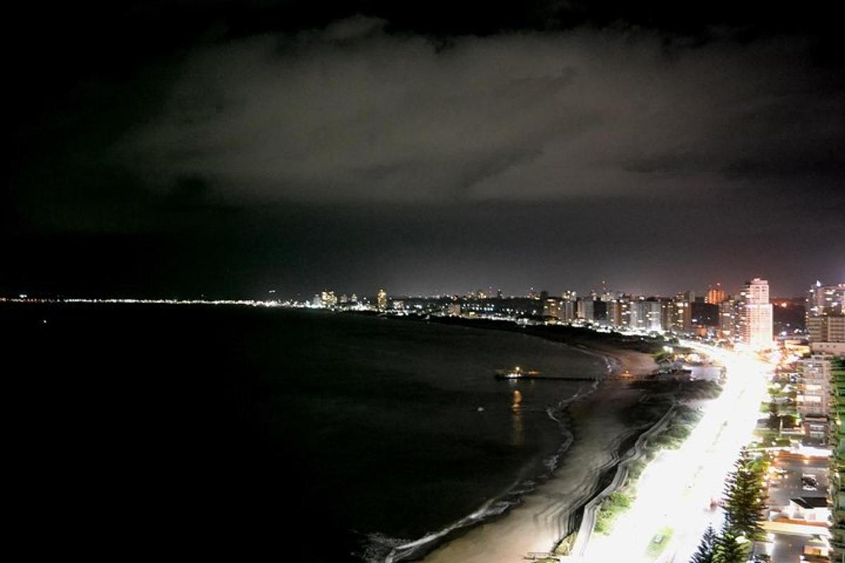 a view of a beach at night with a city