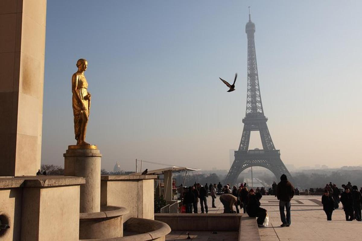 Una estatua de un hombre frente a la Torre Eiffel.