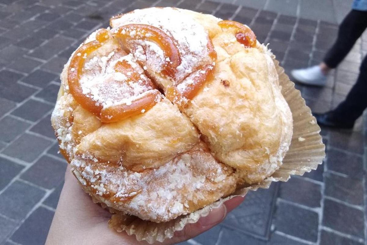 seseorang yang memegang pastri dengan gula tepung di atasnya