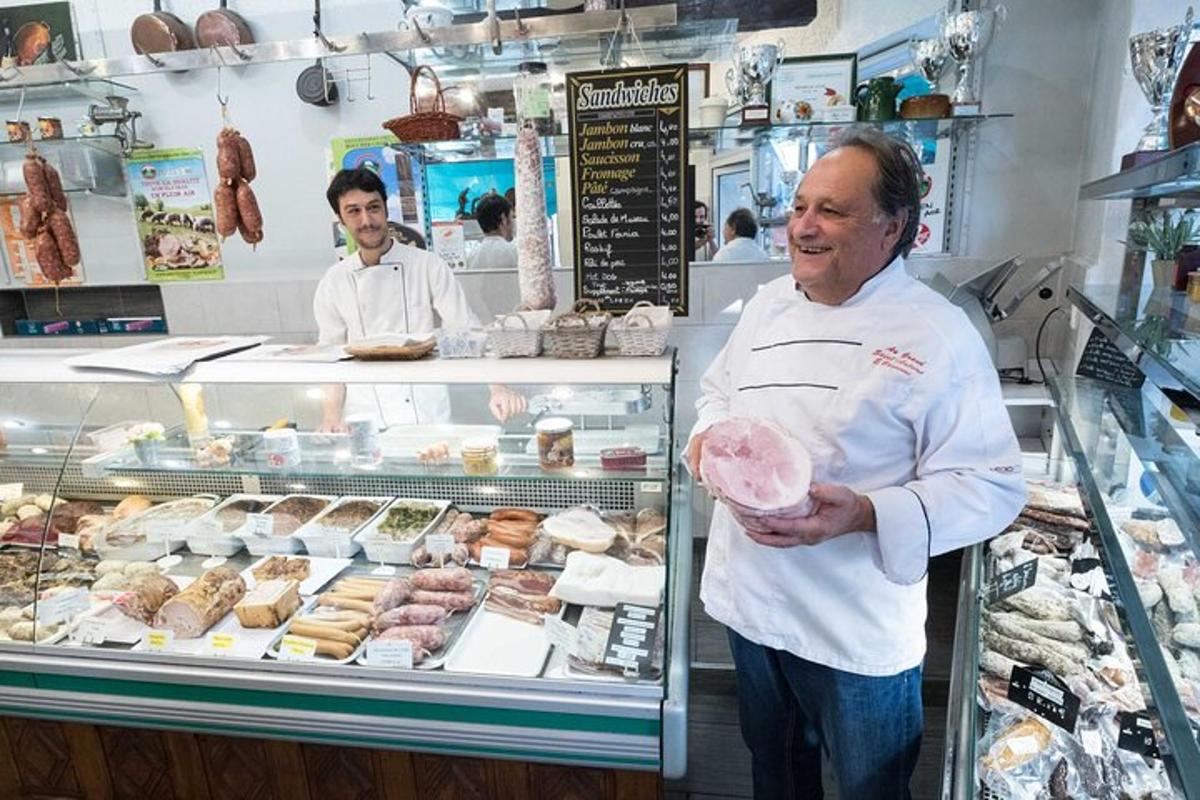 a man standing in a bakery with a doughnut