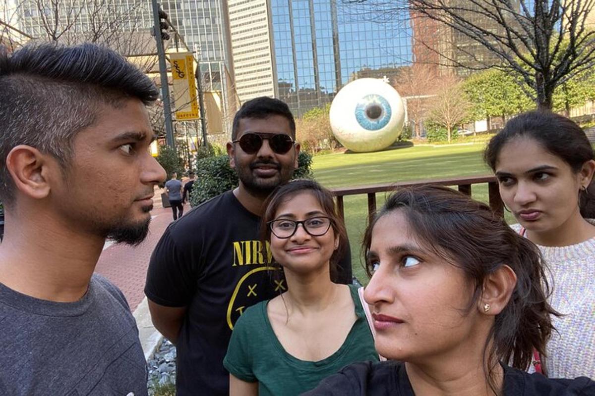 a group of people standing in front of a sculpture