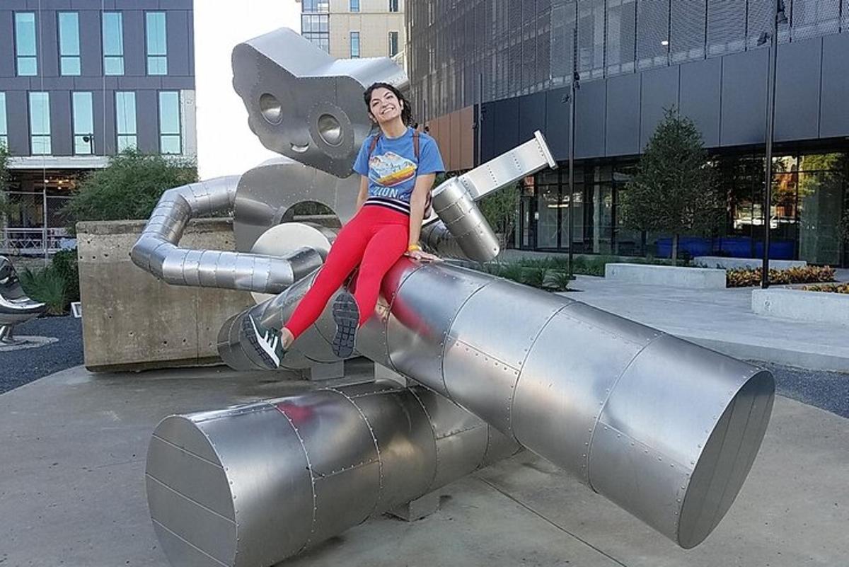 a woman sitting on top of a metal sculpture