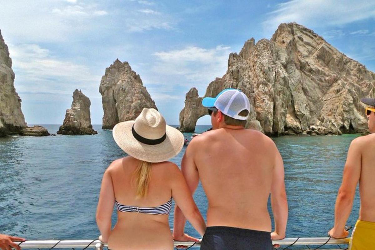 un gruppo di persone sedute su una barca che guardano le rocce nell'acqua