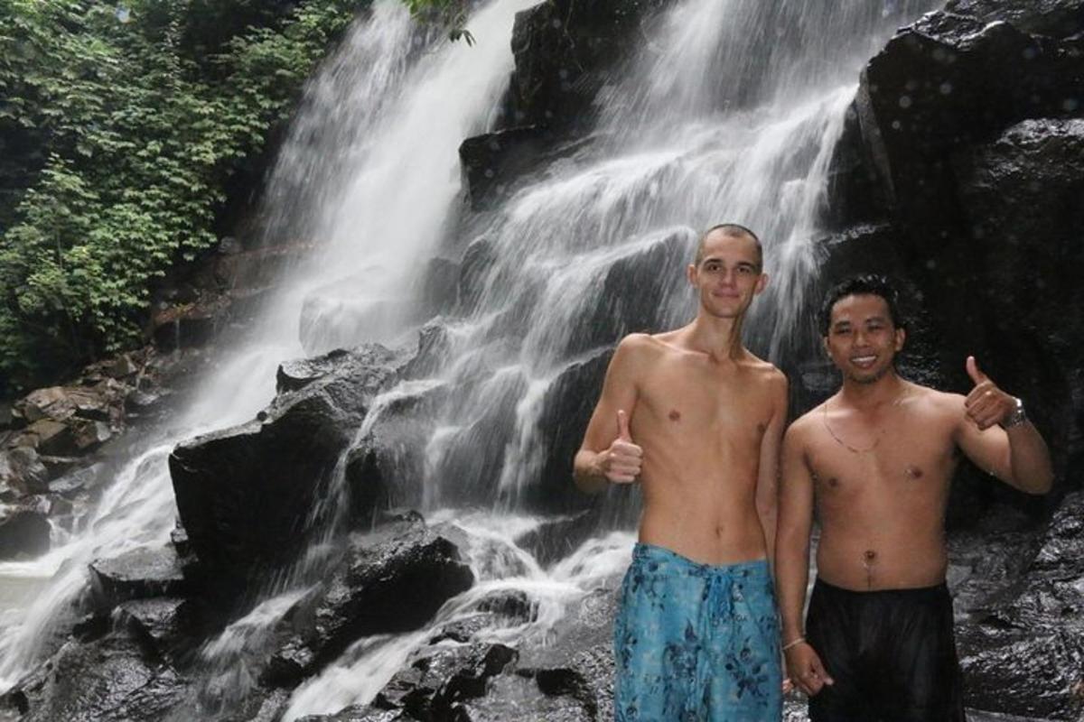 dua lelaki berdiri di hadapan air terjun