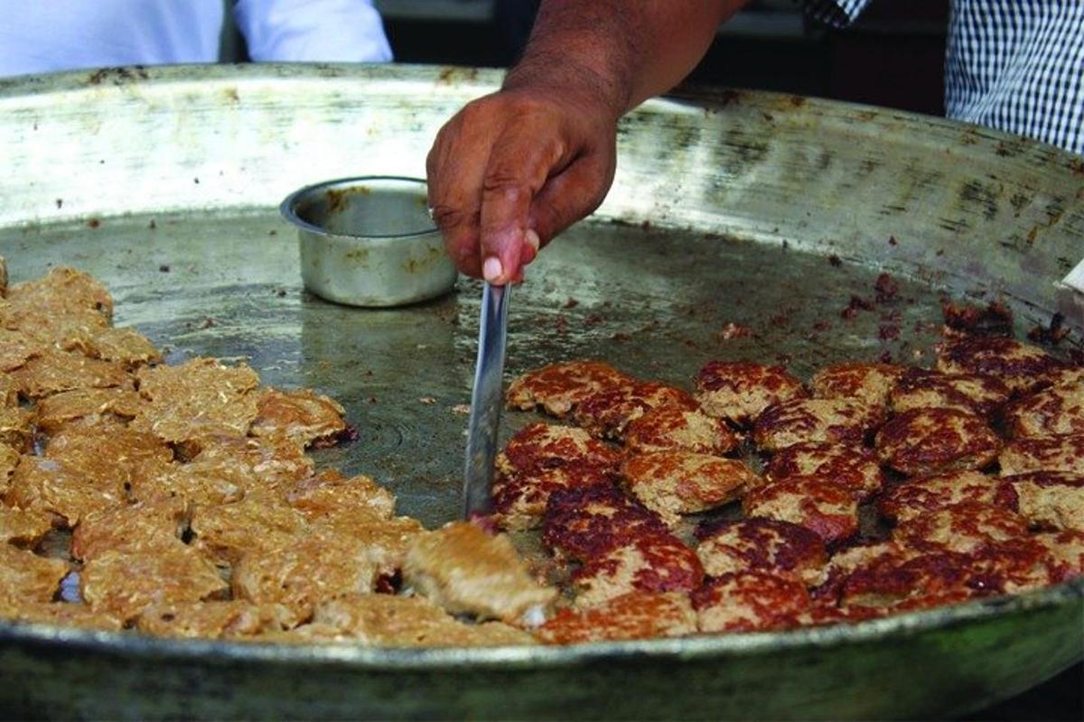 egy személy pizzát szeletel egy serpenyőben