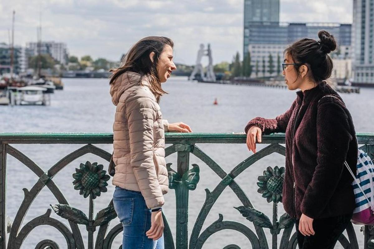 due donne in piedi accanto a una recinzione vicino all'acqua