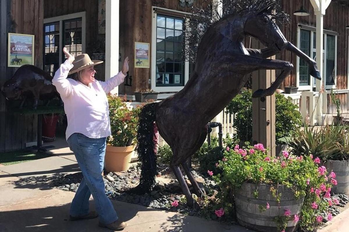 a woman standing next to a statue of a horse