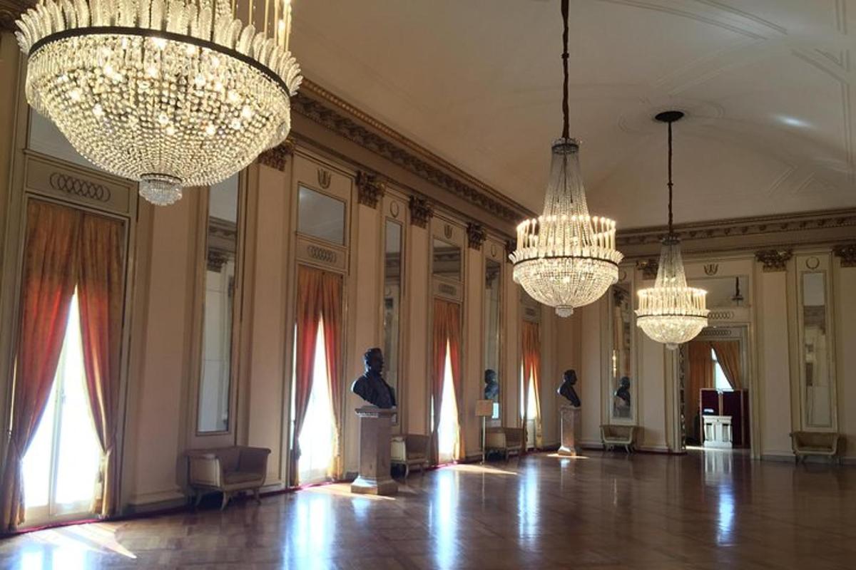 Una gran sala con candelabros y estatuas.