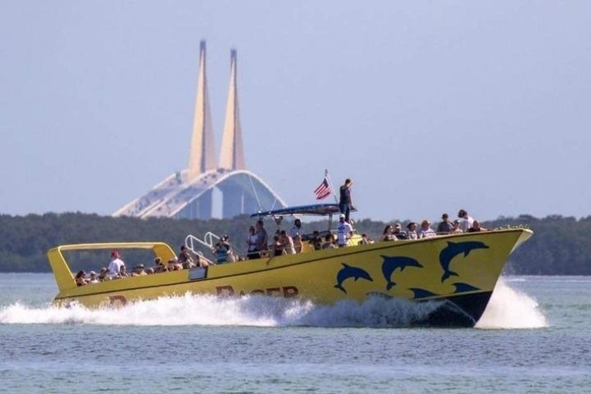 a yellow boat with dolphins on the water