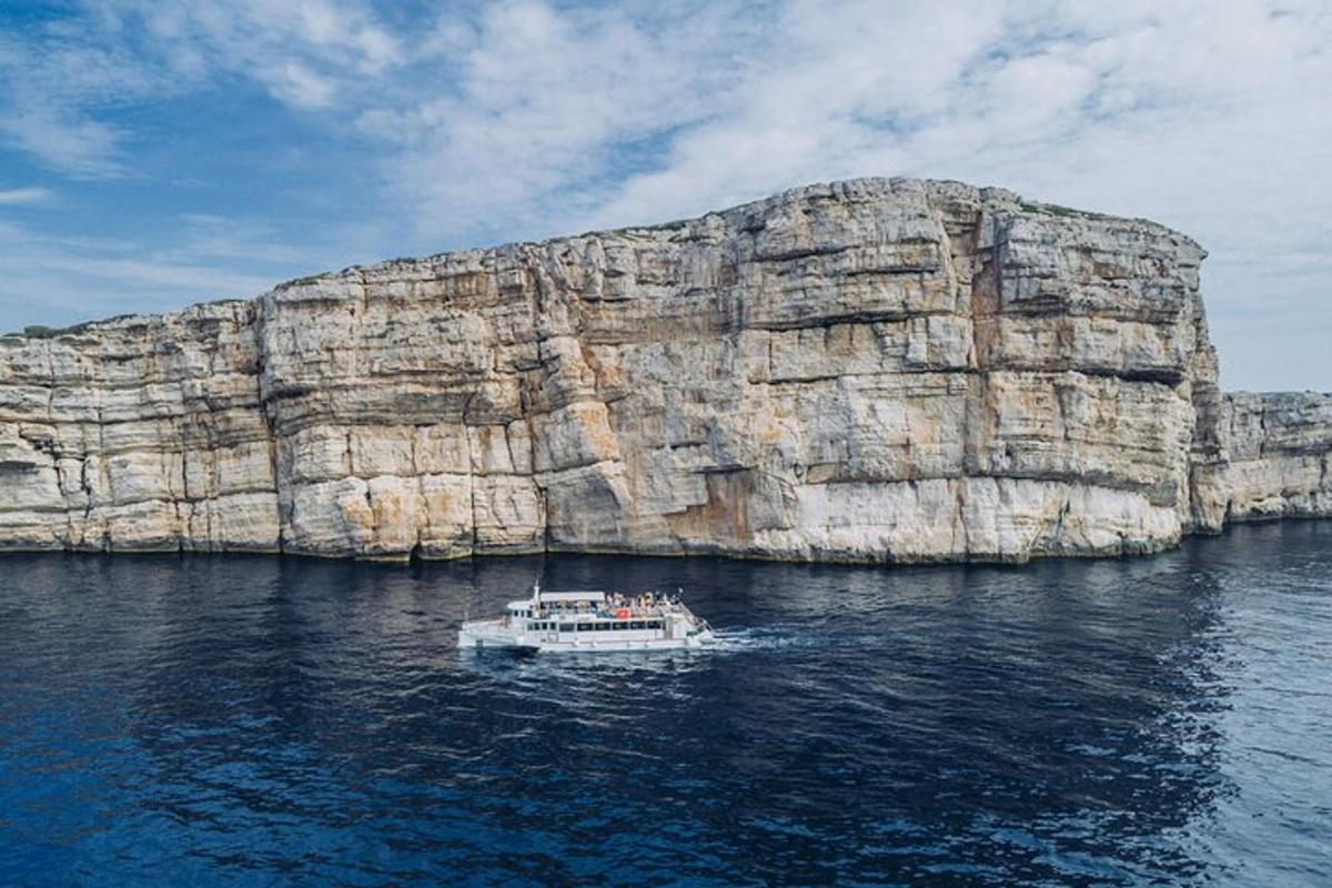 a boat in the water near a large rock formation