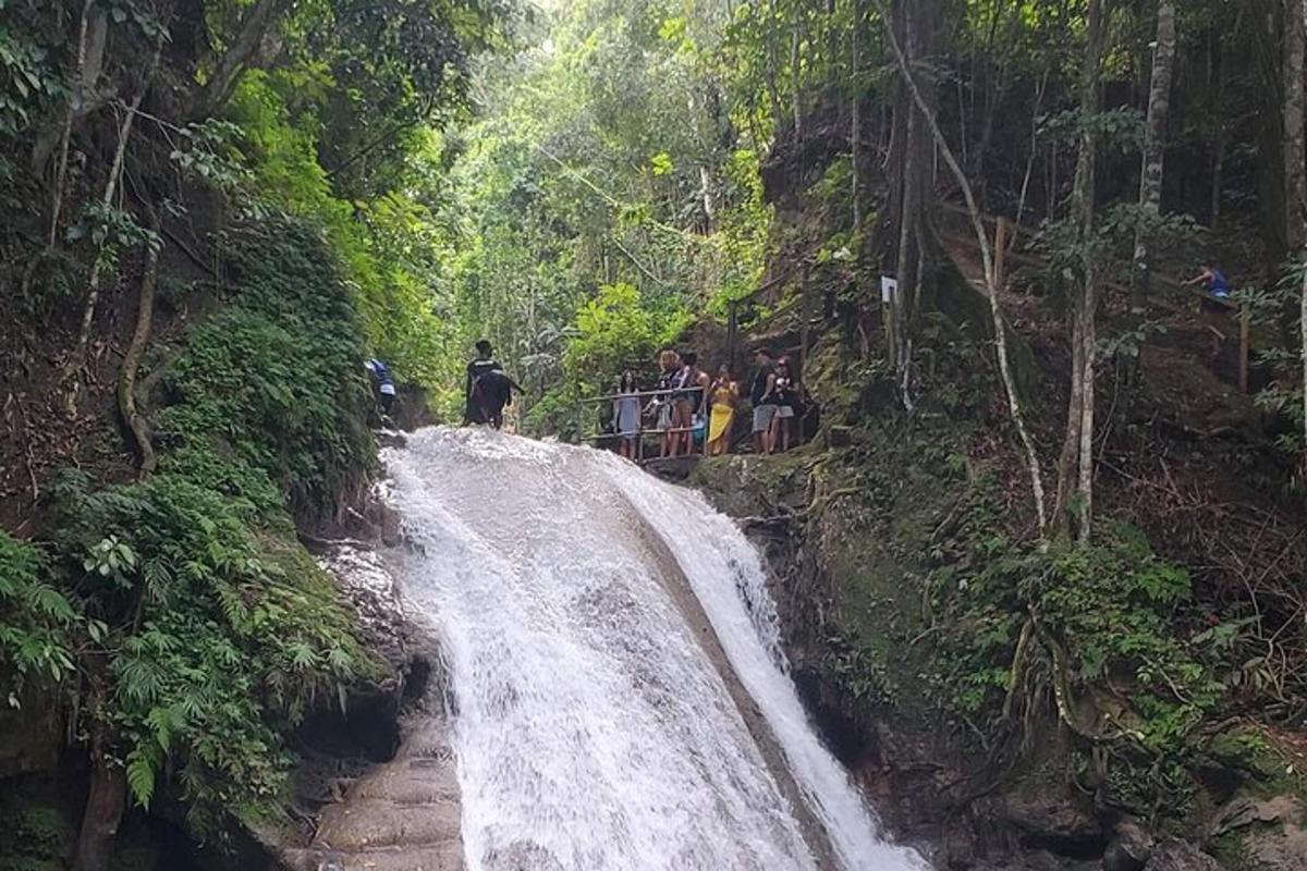 un gruppo di persone in piedi in cima a una cascata