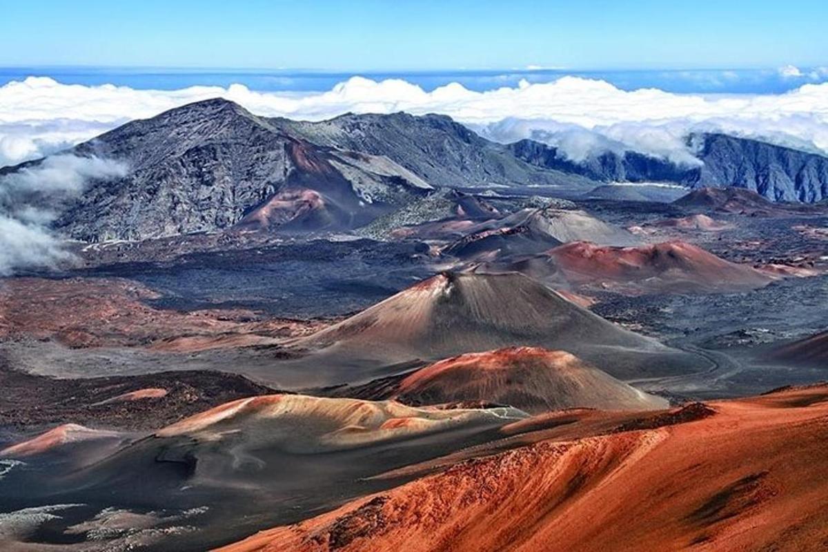 an aerial view of a desert with mountains and clouds