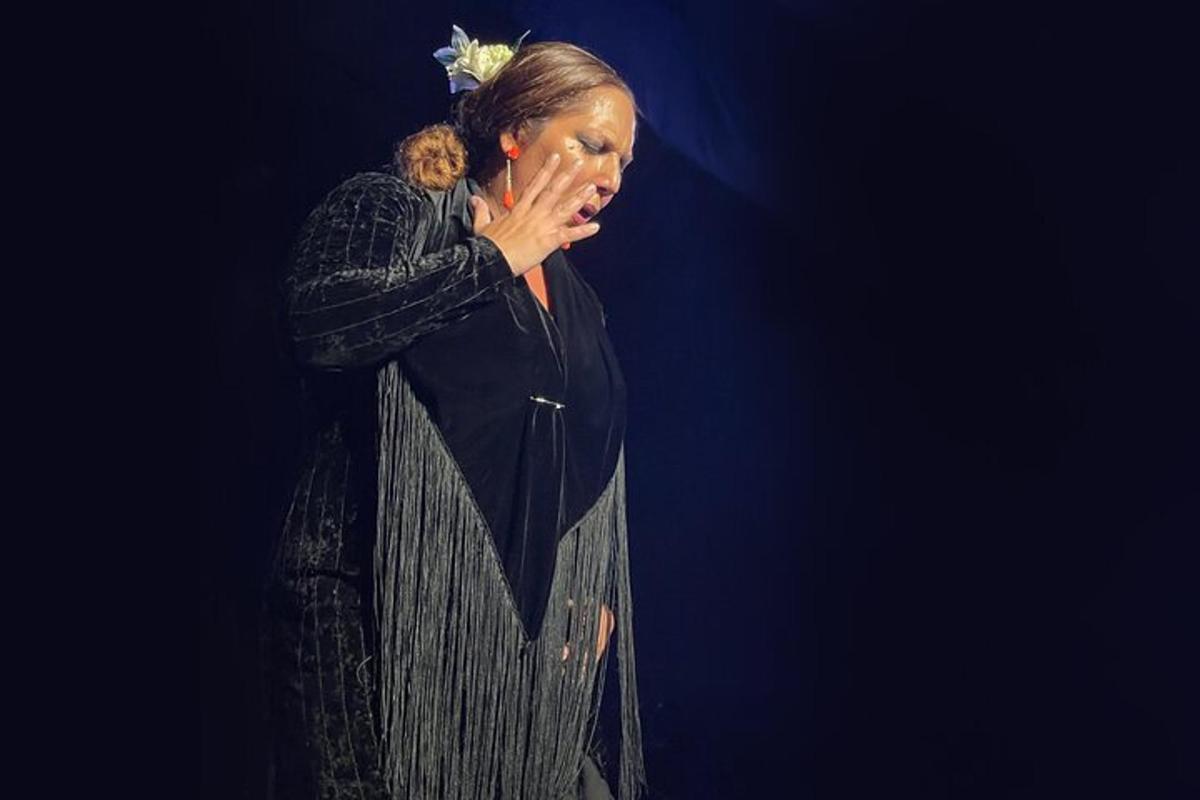 uma mulher em pé no palco com a mão no rosto