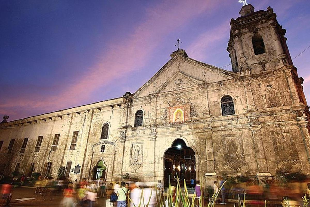 an old church with people standing outside of it