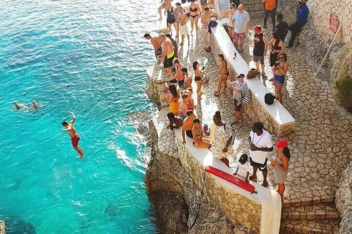 una folla di persone in piedi attorno a una piscina d'acqua