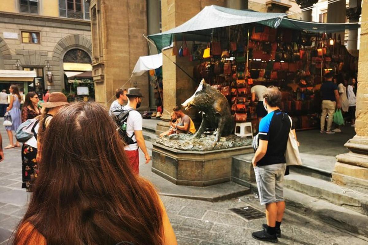 a group of people standing around a market with a statue
