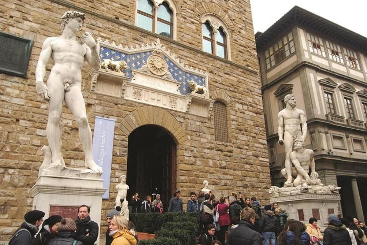 un groupe de personnes debout devant un bâtiment avec des statues
