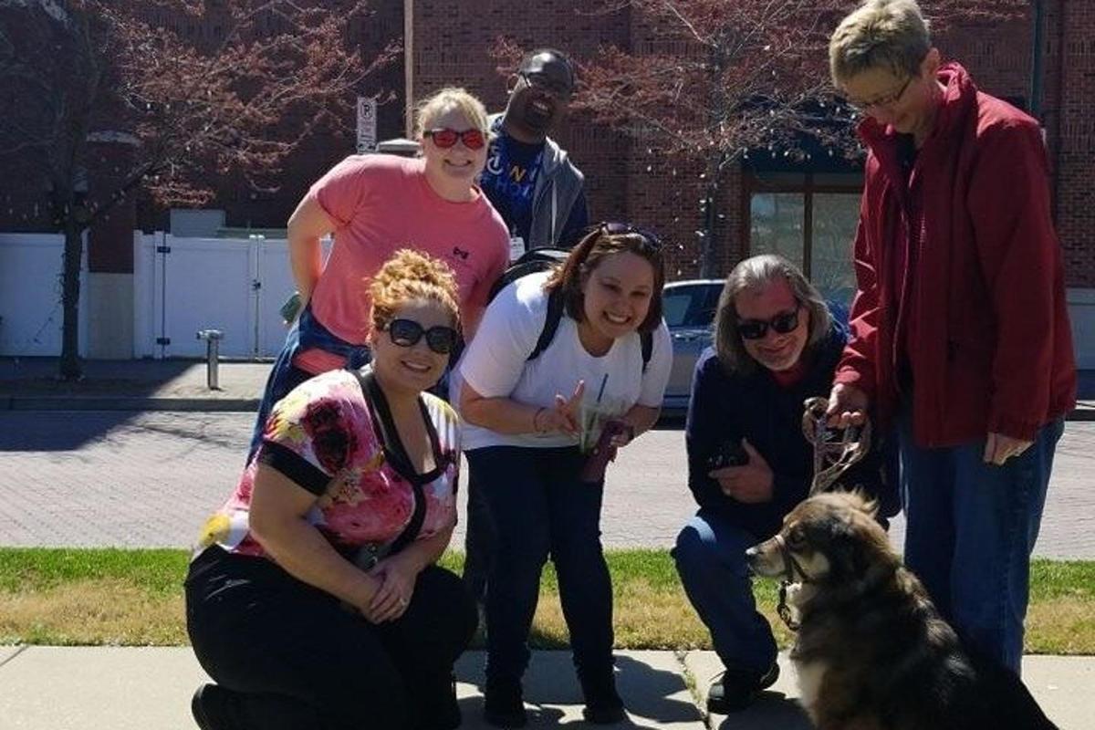 a group of people standing next to a dog