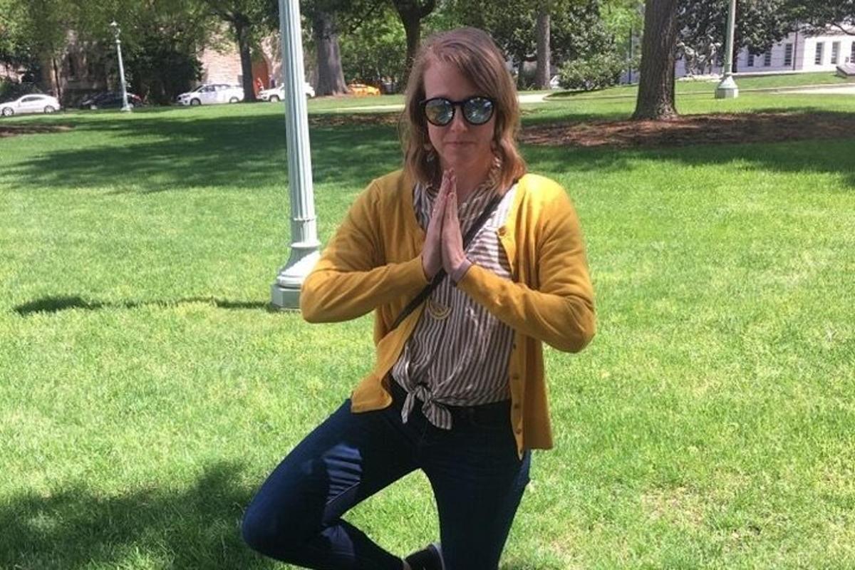 a woman standing in a park with her hands in the air