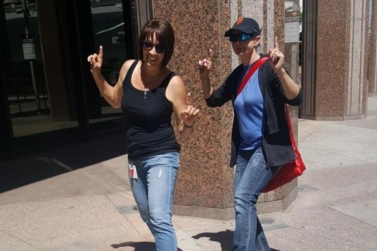 un uomo e una donna camminano per strada con le mani alzate