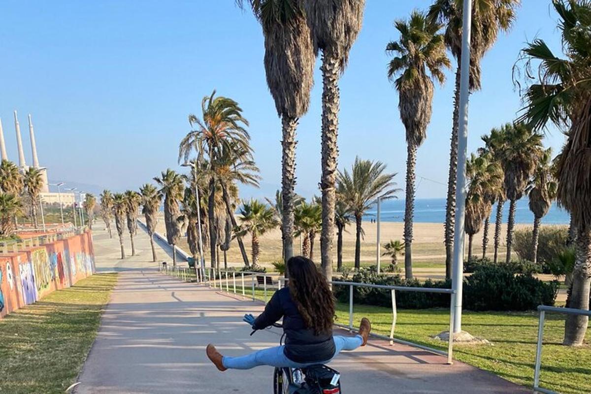 una donna che va in bicicletta lungo un marciapiede con palme