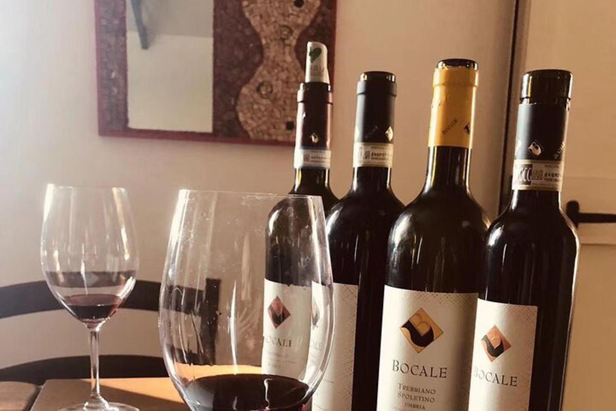 tres ampolles de vi i dues copes sobre una taula