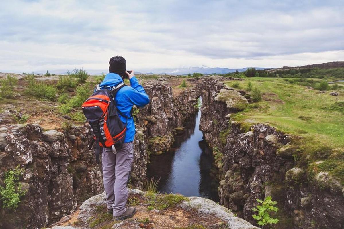 a man standing on a cliff looking at a river