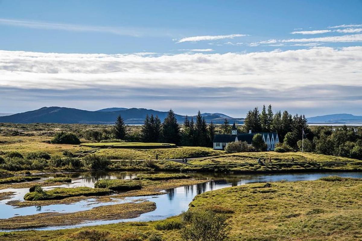 a view of a field with a river and mountains
