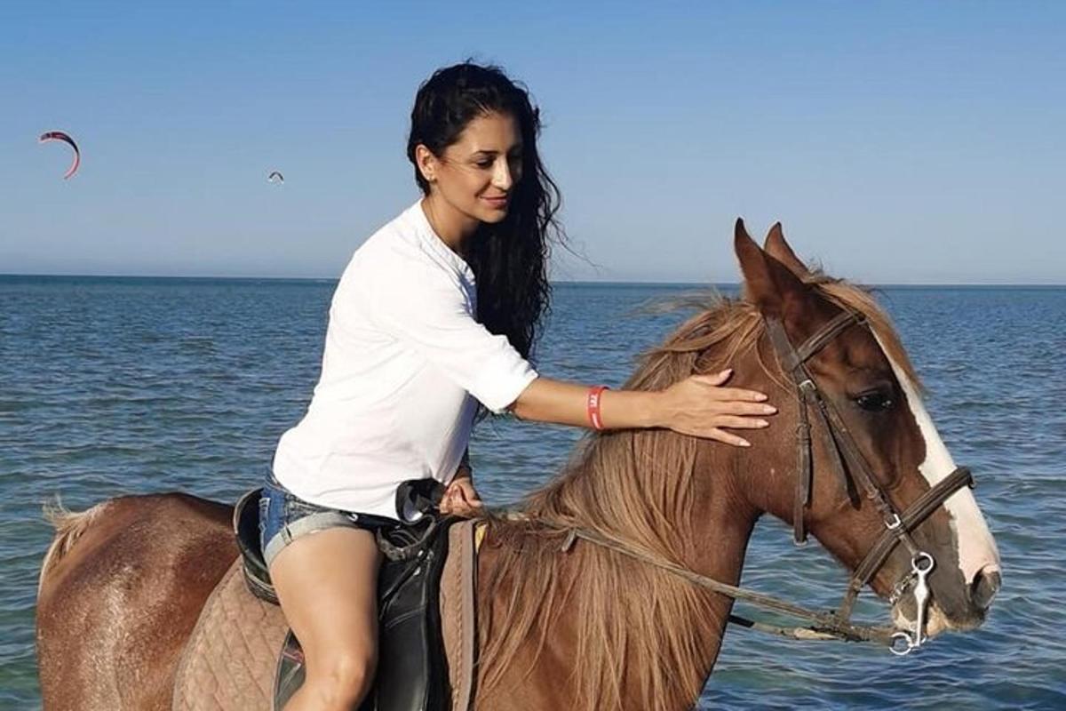 a woman riding a horse in the water