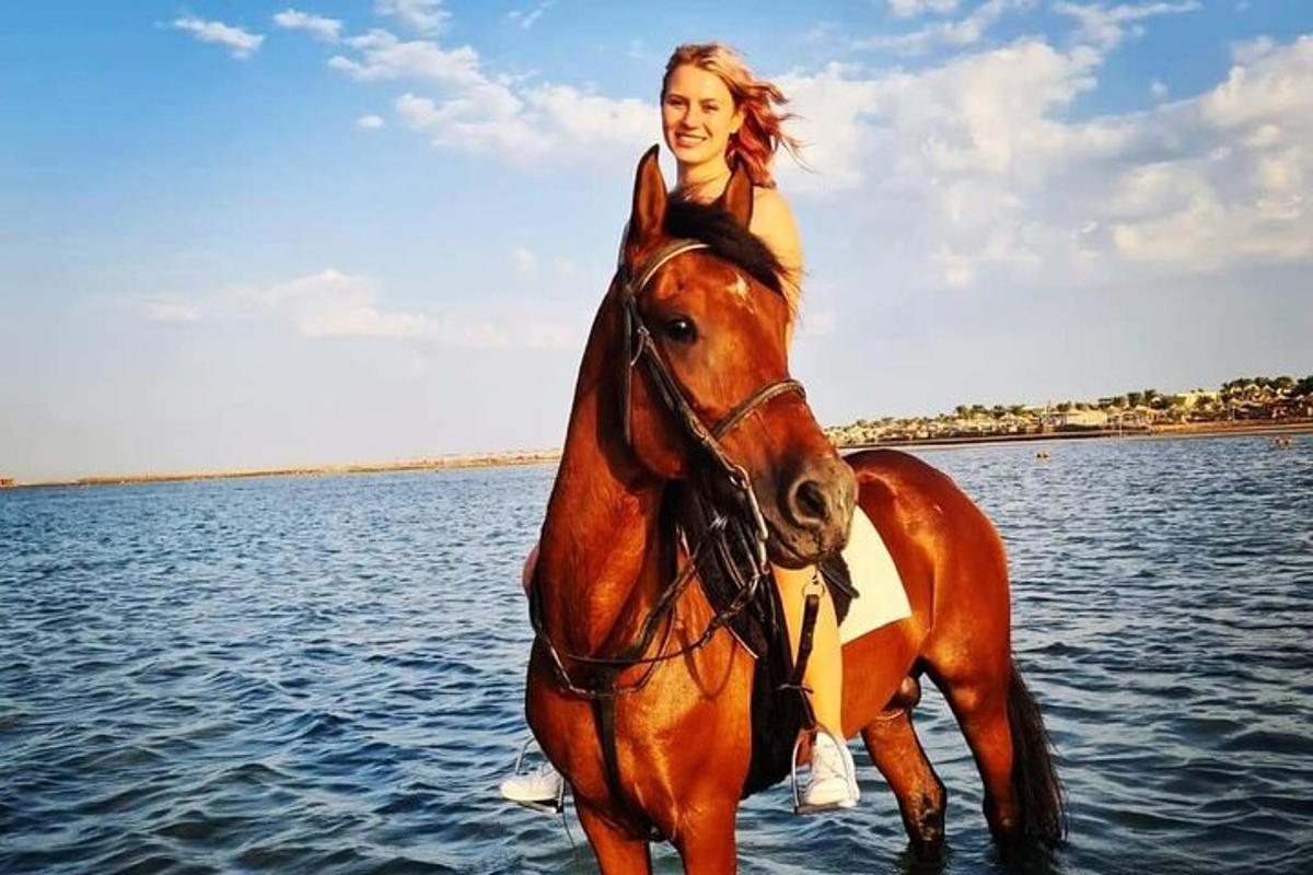 žena jedoucí na koni ve vodě