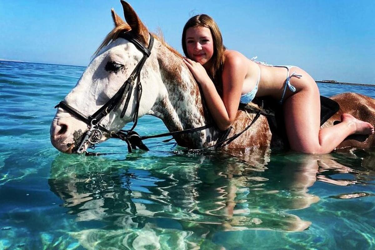 žena jedoucí na koni ve vodě