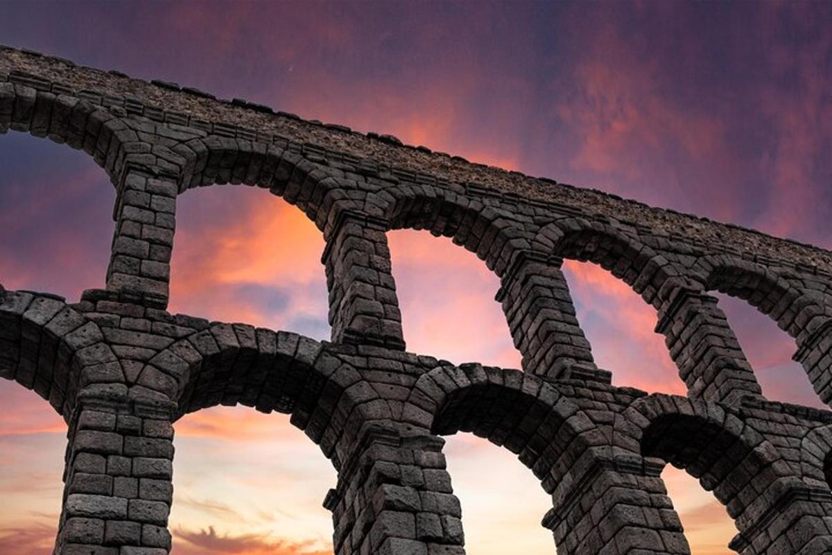 Un edificio con arcos frente a una puesta de sol.