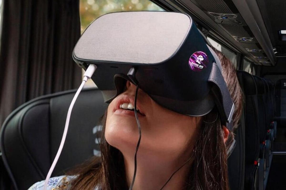 seorang wanita mengenakan helm realitas virtual di dalam bus