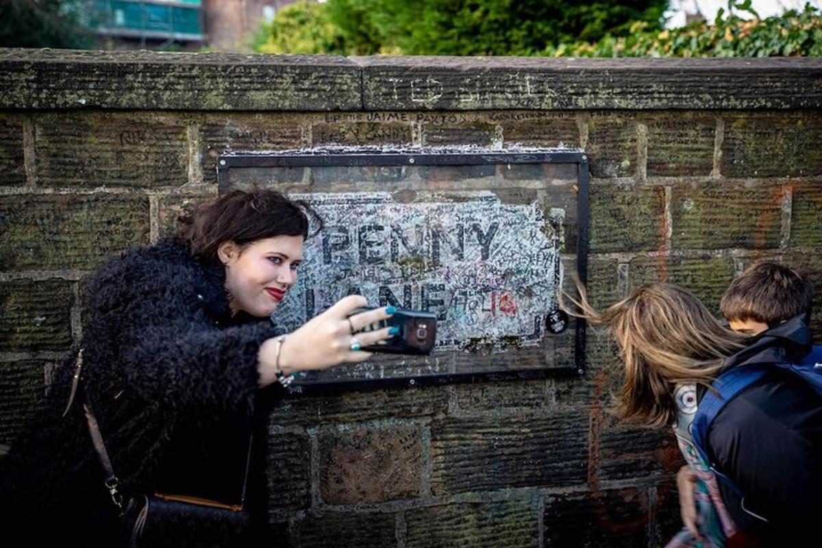 a woman looking at her cell phone on a brick wall
