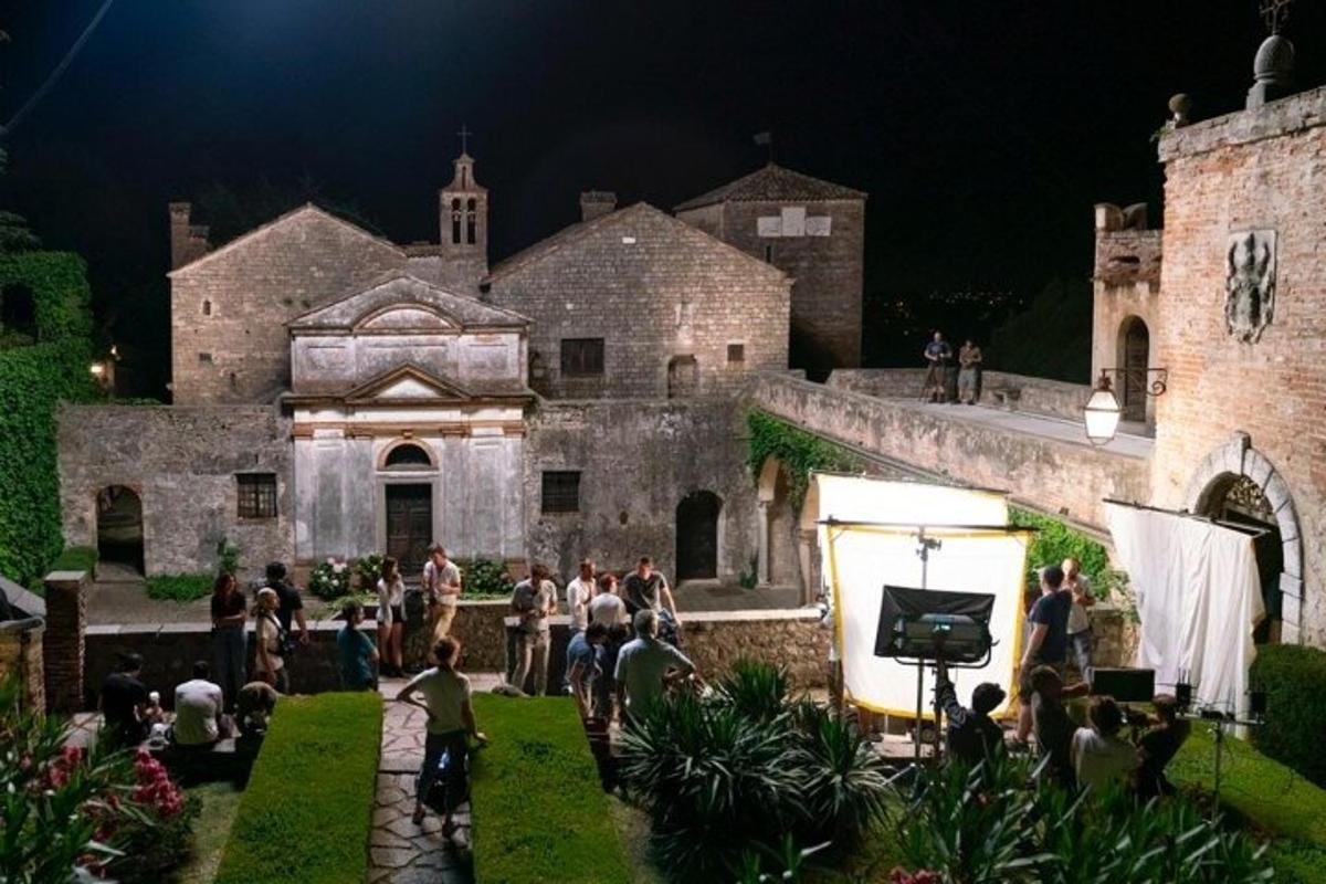 un gruppo di persone in piedi fuori da un castello di notte