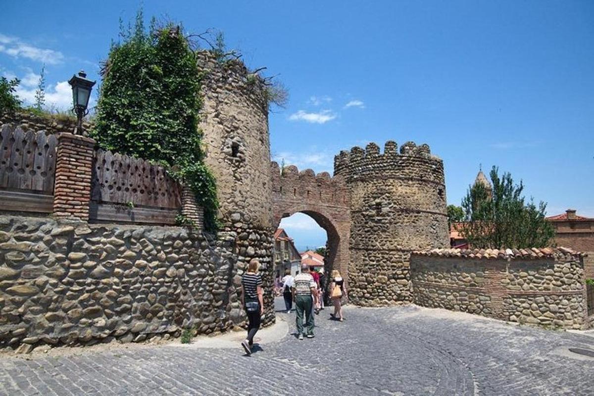 un gruppo di persone che camminano lungo una strada vicino a un castello