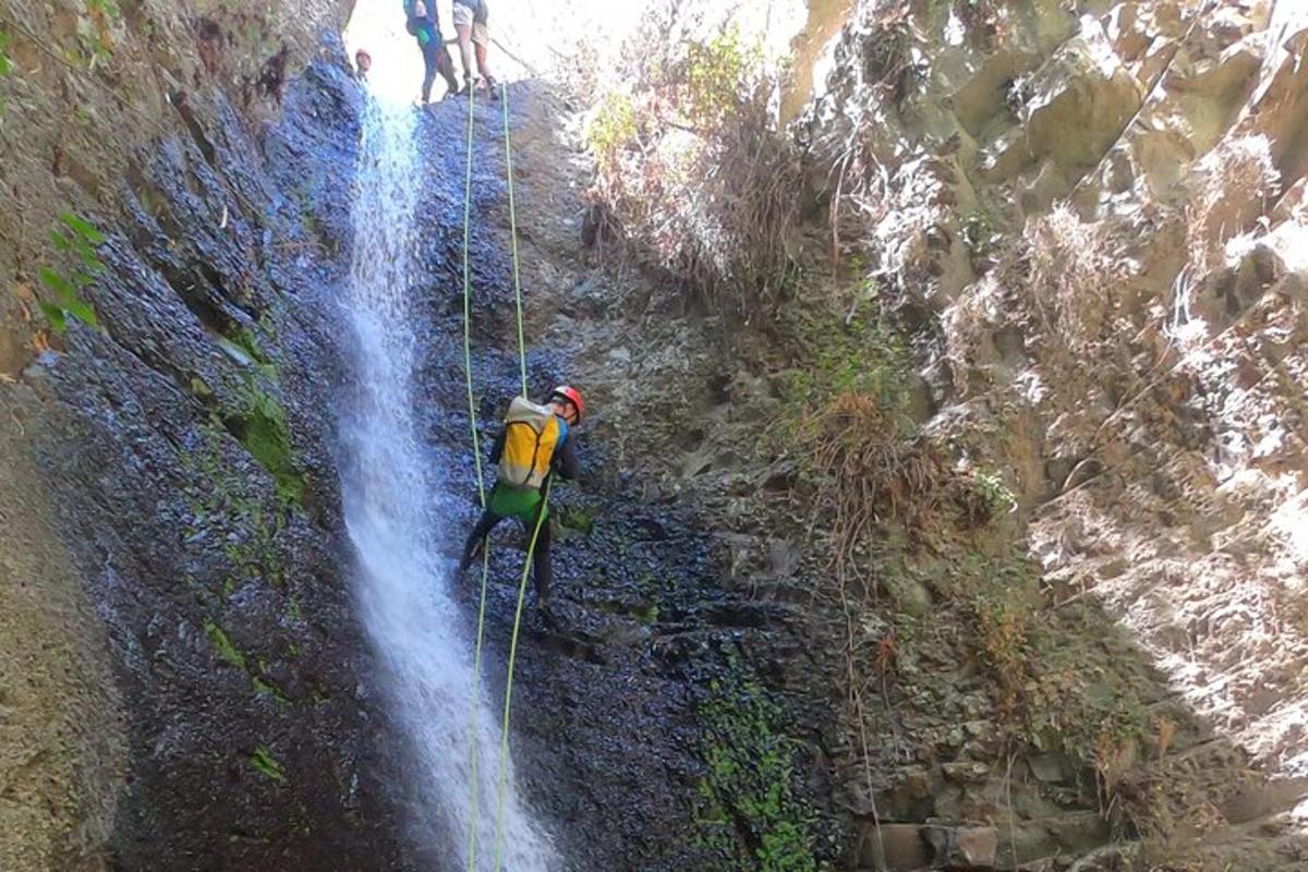 muž na zip line vedle vodopádu