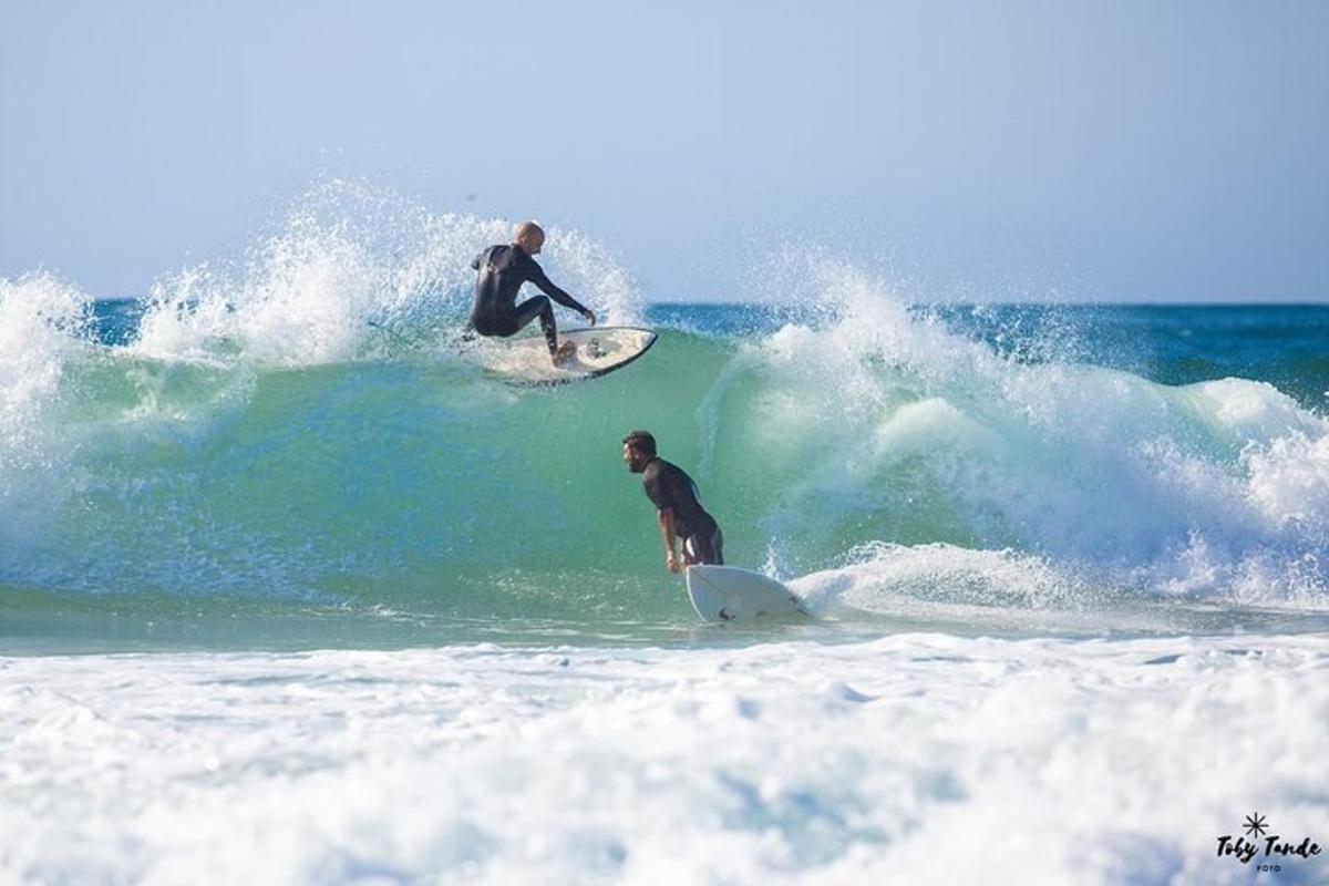 two men riding a wave on surfboards in the ocean