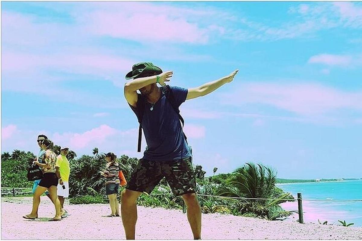 seorang lelaki berdiri di pantai dengan frisbee