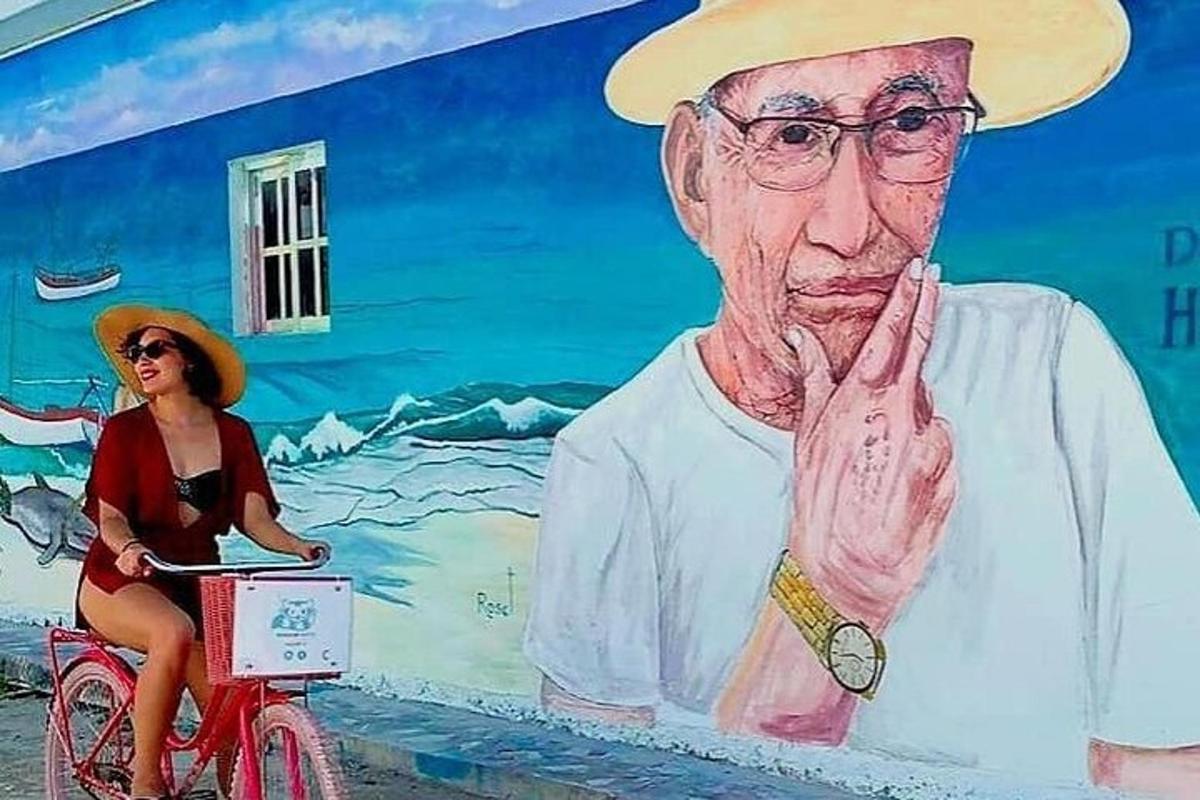 una dona anant en bicicleta davant d'un mural