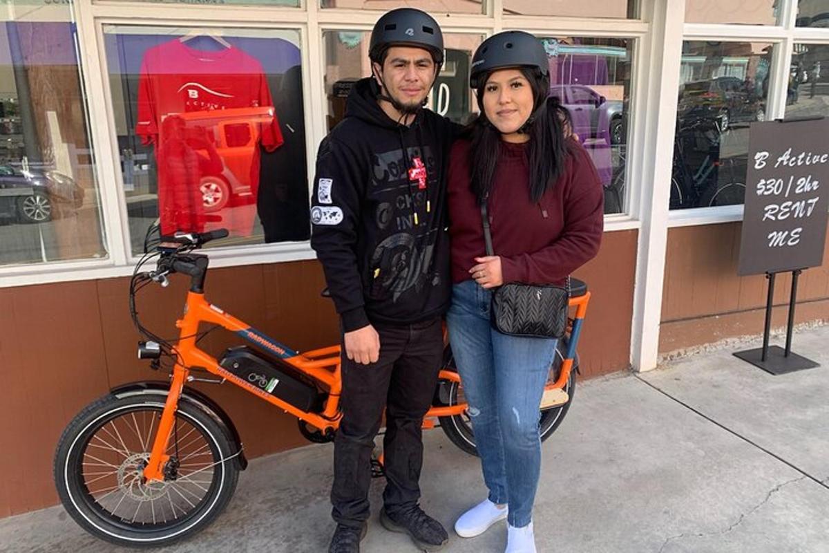 a man and a woman standing next to a motorcycle