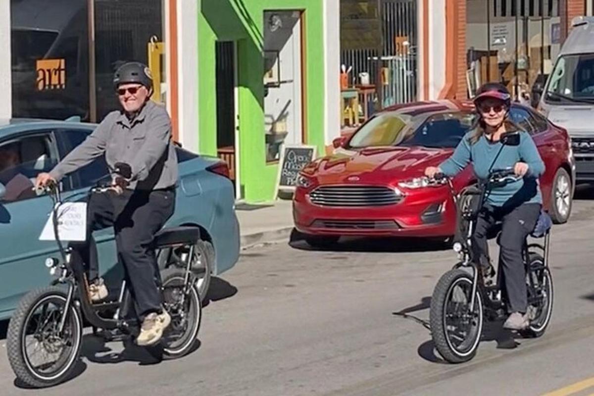 a man and a woman riding bikes down a street